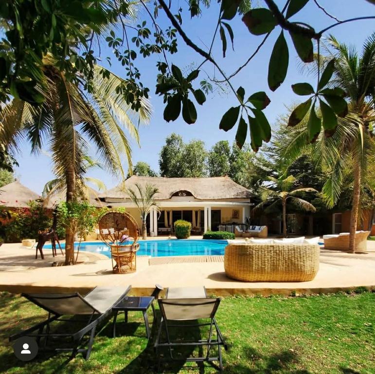 a villa with a swimming pool and a house at Bandam Lodge in Ngaring