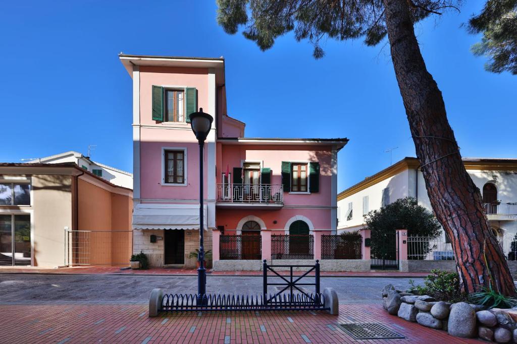 a pink house with a tree in front of it at Residenza Colombi Goelba in Marina di Campo