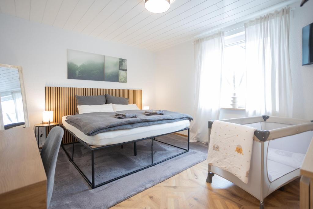a bedroom with a bed in a room with windows at City Green Appartement in Bad Lippspringe