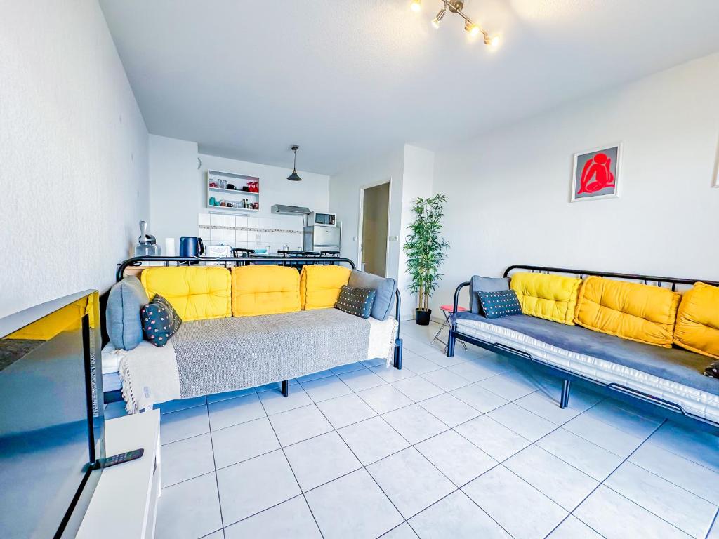 a living room with two couches and yellow cushions at Apartment 4 pers avec Terrasse in Sète