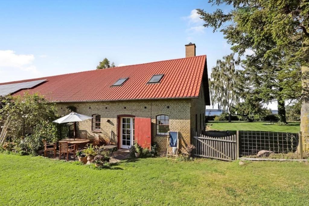 an old brick house with a red roof at Charming apartment by forest & beach on Tåsinge in Svendborg