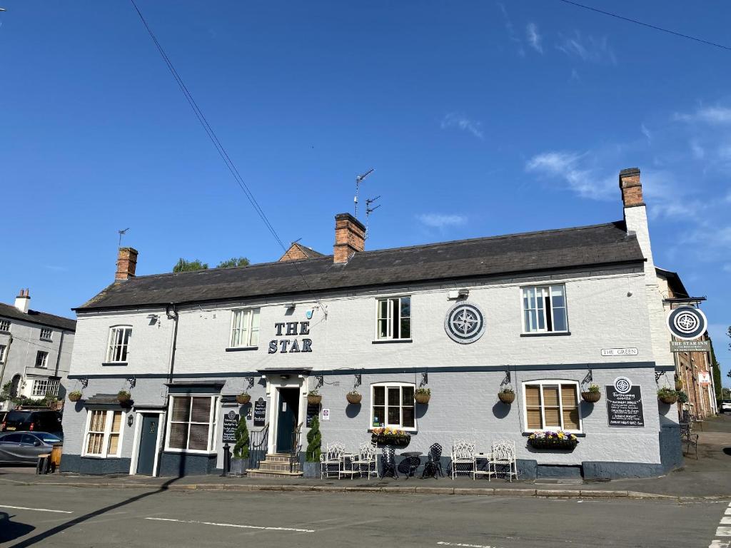 a white building on the corner of a street at The Star Inn 1744 in Thrussington