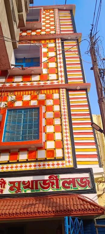a tall building with an orange and white at Mukherjee Lodge in Rāmpur Hāt