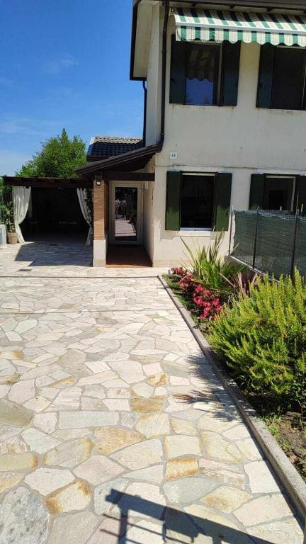 a building with a stone driveway in front of a building at TRAGHETTO VECCHIO HOUSE in Cavallino-Treporti