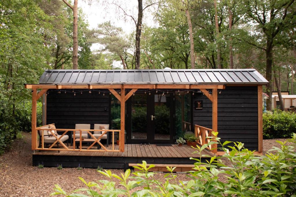 a wooden cabin with a table and a roof at Kapschuur in Zuidwolde