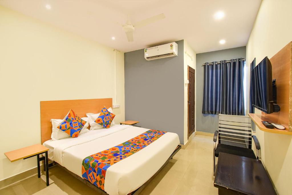 a bedroom with a bed and a desk and a television at FabHotel Vedhanshi in Hyderabad