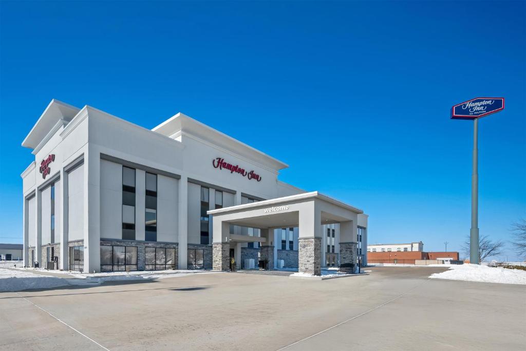 a white building with a sign in front of it at Hampton Inn Bloomington West in Bloomington