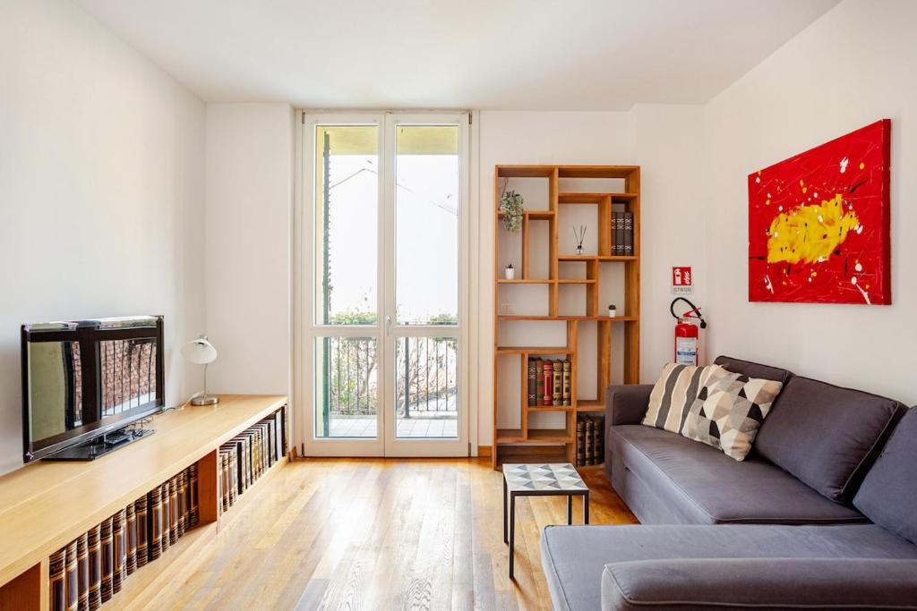 a living room with a couch and a tv at Independent house private garden in Milan