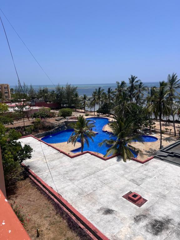 an overhead view of a swimming pool with palm trees at Ocean Crown Apartments in Mombasa