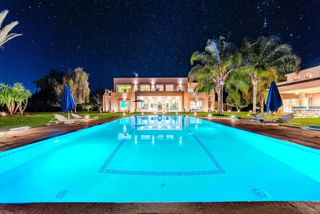 a swimming pool in front of a house at night at Palais Pyar Luxury and Serenity Setting in Najem