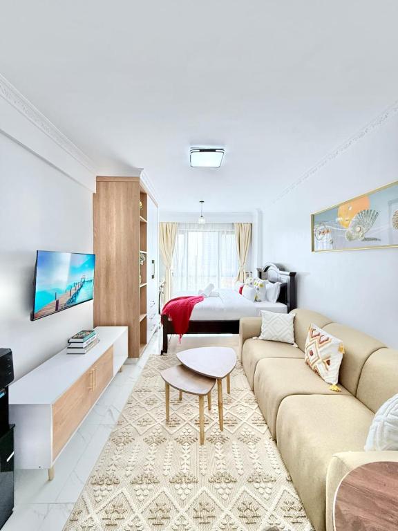 a living room with a couch and a bed at The Kilimani Executive Studio Haven with Gym&Restaurant in Nairobi