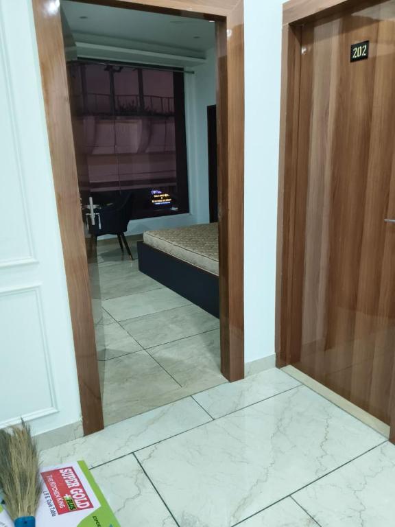 a door leading into a living room with a mirror at hotel apple tree in Bahādurgarh