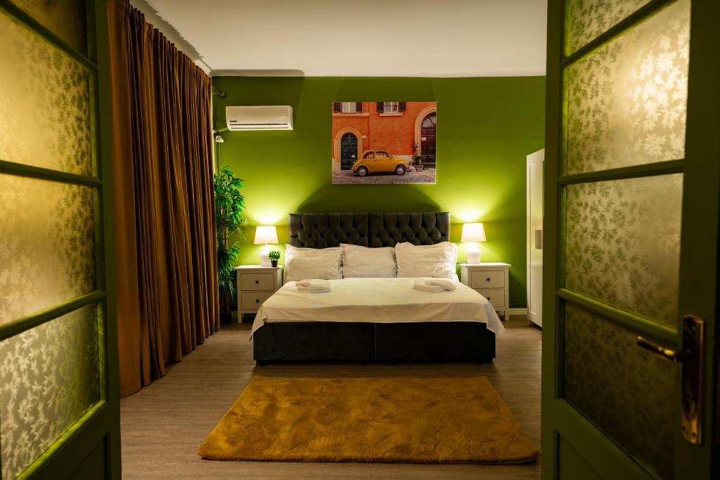 a bedroom with a bed and a green wall at Pit Stop Centrum in Ploieşti