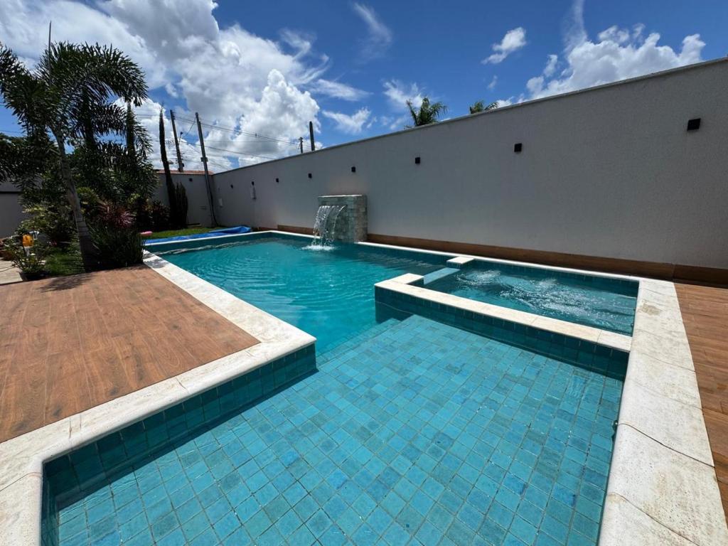 a swimming pool with blue tiles on the side of a building at Espaço completo MOTO GP in Aparecida de Goiânia