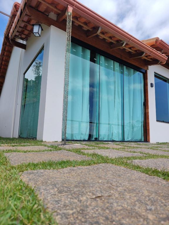 a building with large glass windows on it at Chalé Vista pra Lombada in Conceição da Ibitipoca