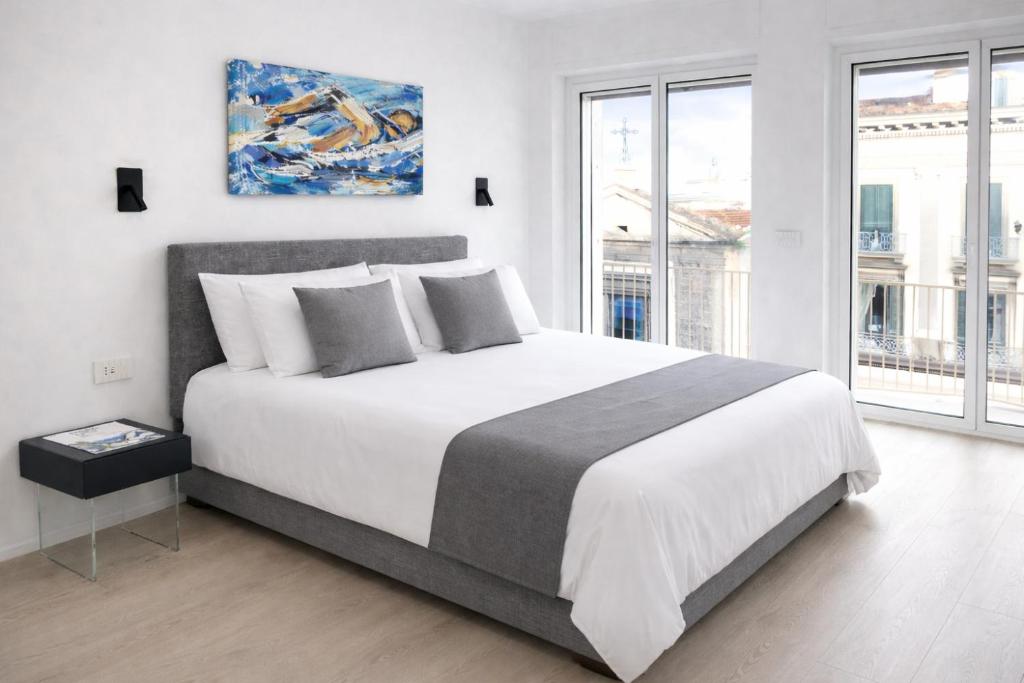 a bedroom with a large bed and a large window at Fiorentini Residence NAPOLI in Naples