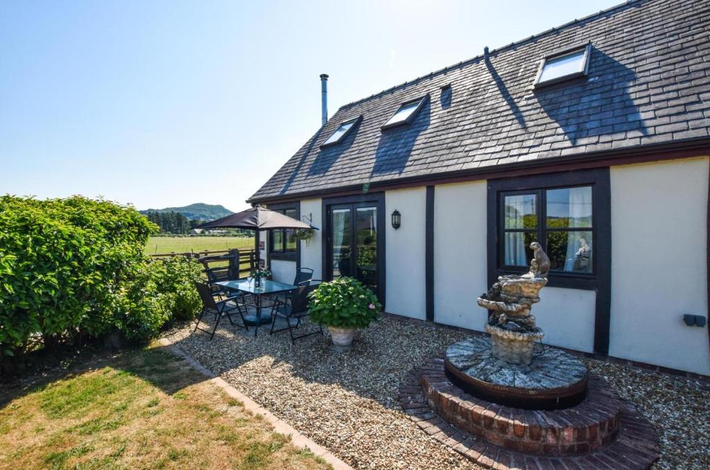 a house with a fountain in front of it at 2 Bed in Welshpool oc-75703 in Meifod