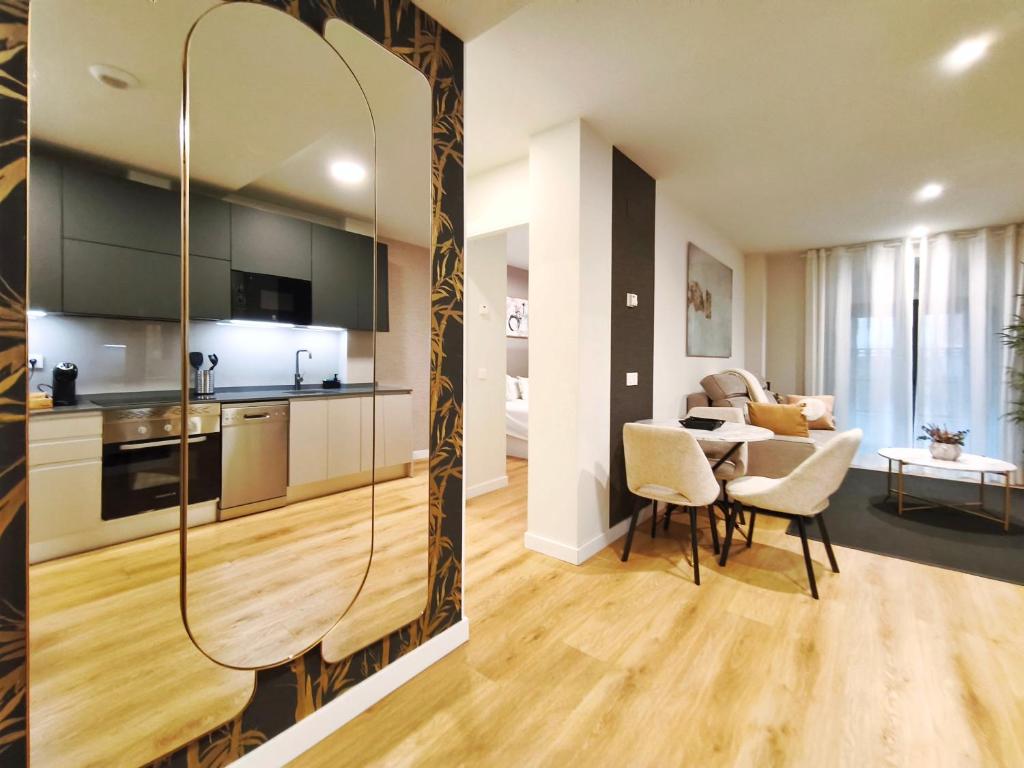 a kitchen and a living room with a table and chairs at Apt 1 hab Catedral III, Parking, Centro Valladolid in Valladolid
