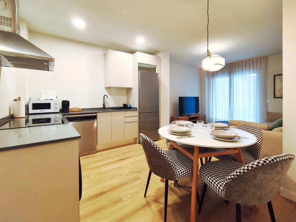 a kitchen and living room with a table and chairs at Apt 2 hab Catedral II, Terraza, Parking, Centro in Valladolid