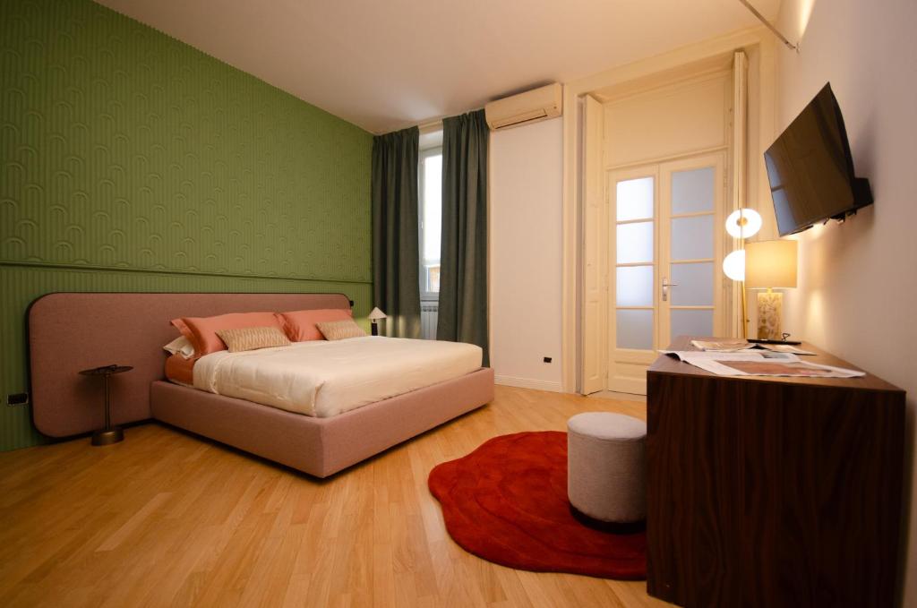 a green bedroom with a bed and a television at The Orso Suite -Brera in Milan