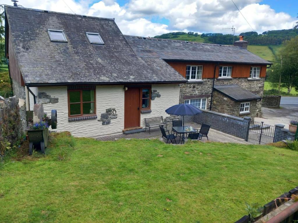 a house with a table and chairs in the yard at 2 Bed in Machynlleth oc-wad305 in Cemmaes