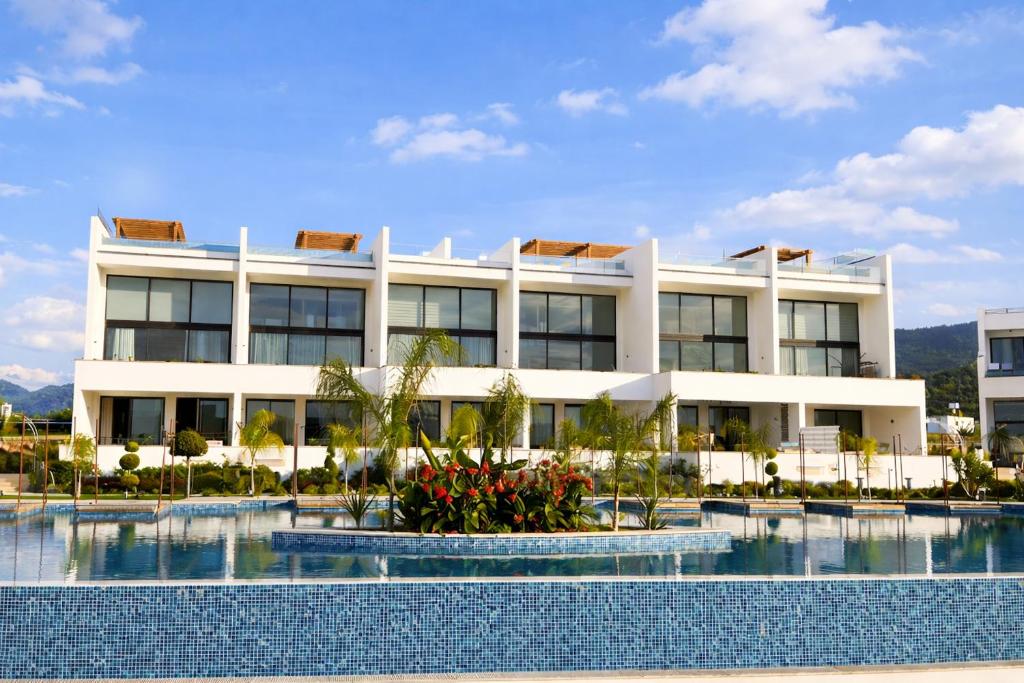 a large white building with a pool in front of it at Mykonos Homes Cyprus in Kyrenia