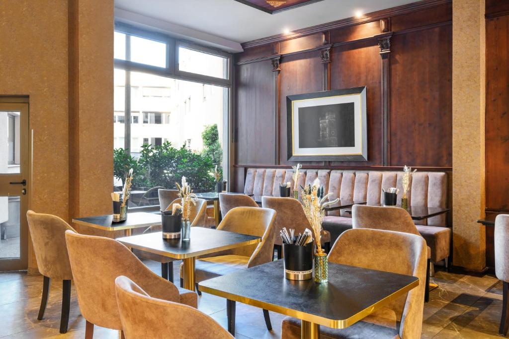 a restaurant with wooden walls and tables and chairs at KING's Hotel First in Munich
