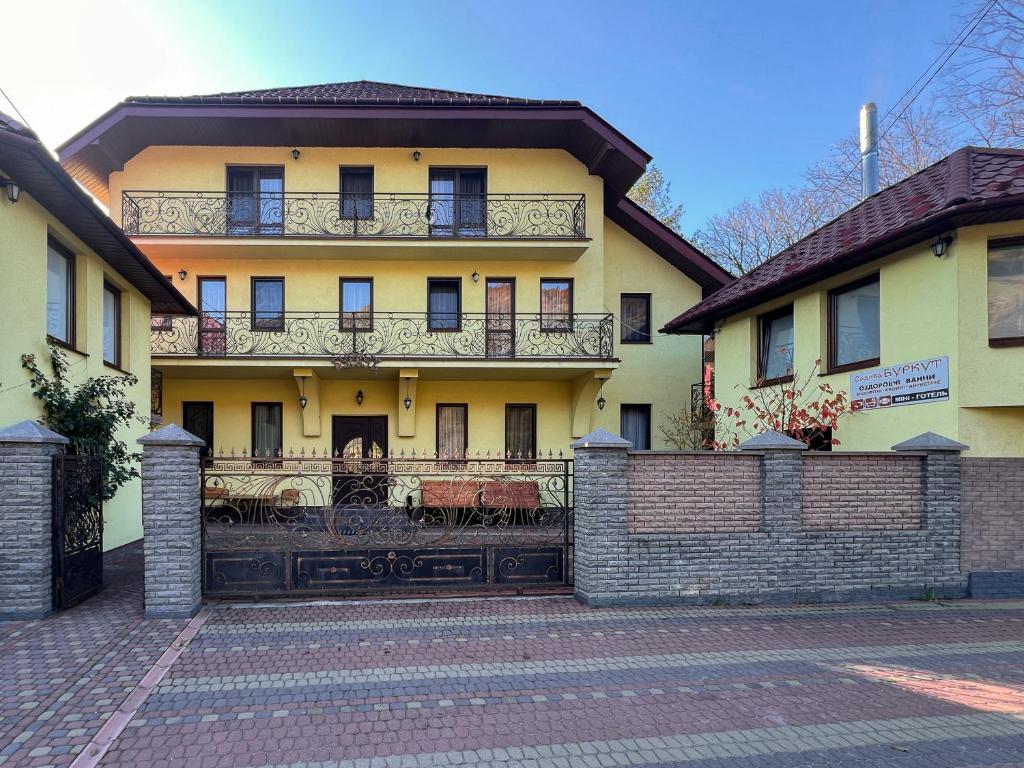 a large house with a fence in front of it at Садиба Буркут in Kvasy