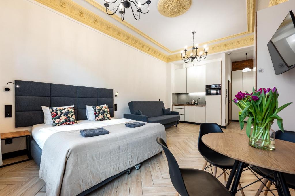 a bedroom with a large bed and a table and chairs at Pod Błękitnymi Podkowami in Wrocław
