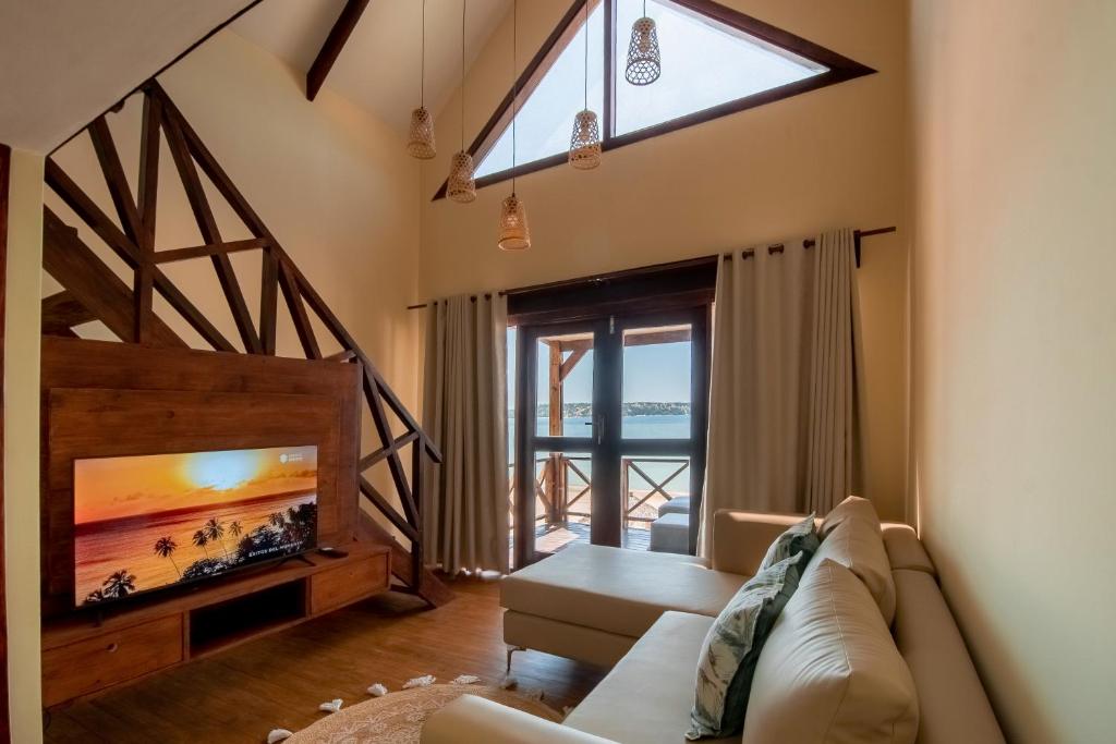 a living room with a couch and a tv at Complexo Palmeiras Bilene in Vila Praia Do Bilene