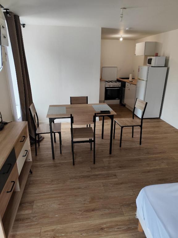 a room with a table and chairs and a kitchen at studio confort a prix doux in Selles-sur-Cher