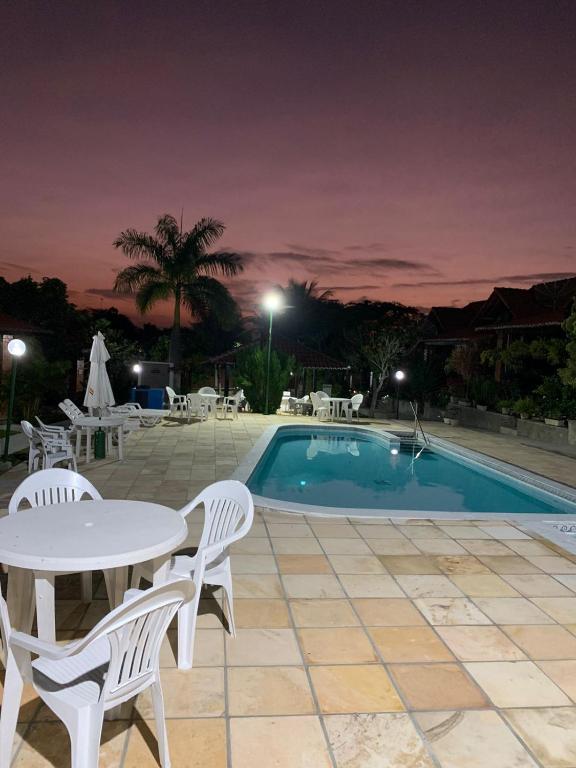 a patio with a table and chairs next to a pool at Chalé Gravatá 2022 in Gravatá