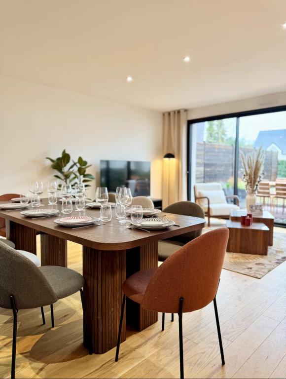 a dining room with a table with wine glasses on it at La Maison Contemporaine, Luxe et Elégance aux portes de Rennes in Cesson-Sévigné