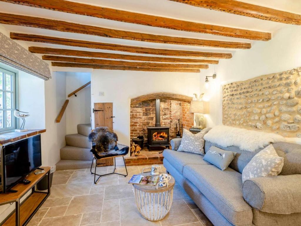 a living room with a couch and a fireplace at 1 Bed in Holt oc-78233 in Cley next the Sea