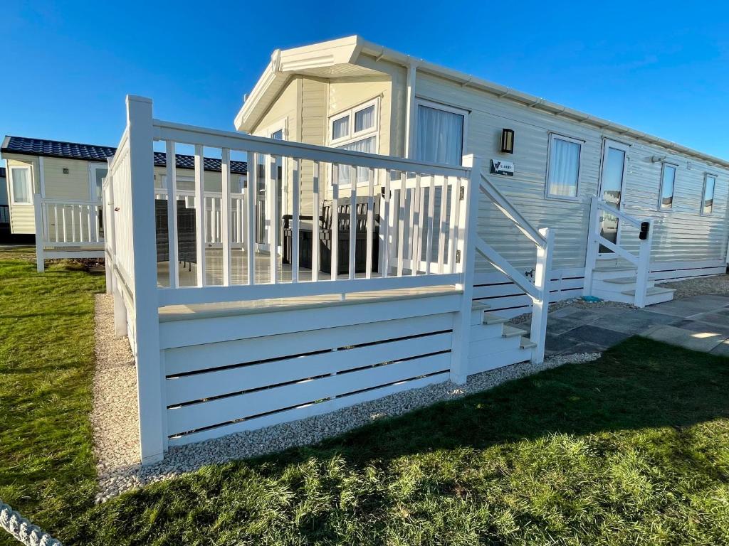 a white fence around a mobile home at Fairview Caravan Hire in Lossiemouth