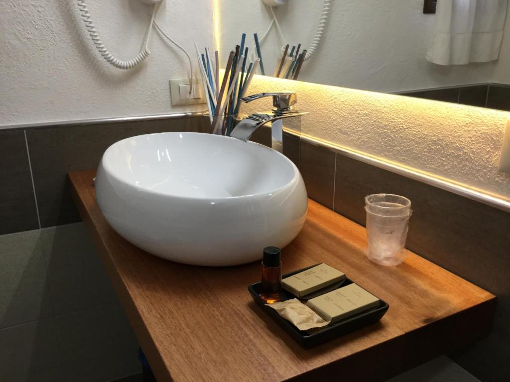 a white sink on a wooden counter in a bathroom at Villa Kuky in Santa Teresa Gallura