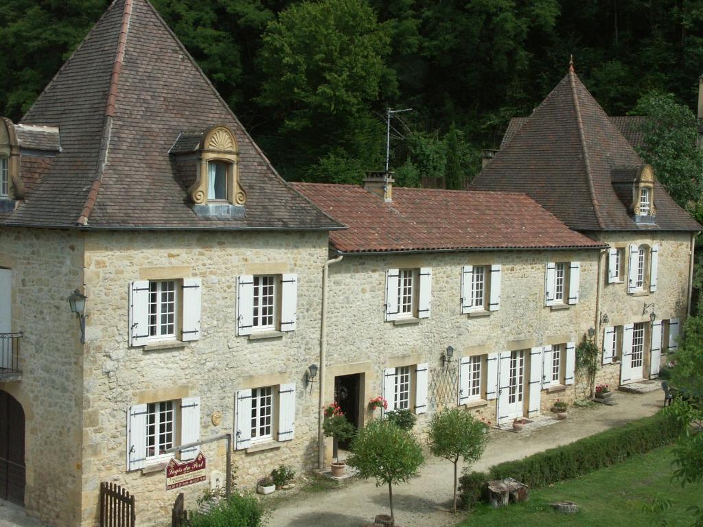 an old stone building with white windows and roofs at Le Logis du Port in Domme