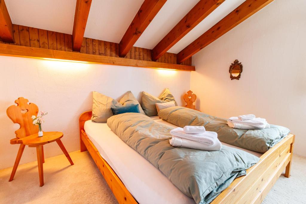 two beds in a room with wooden beams at Ferienhaus Grundschera Engadin in Brail