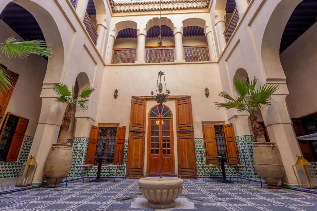 a building with a fountain in the middle of a courtyard at Riad Sarasvati & SPA in Marrakesh
