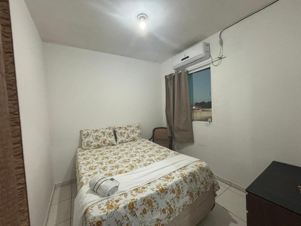 a small bedroom with a bed and a window at Apartamento in Maragogi