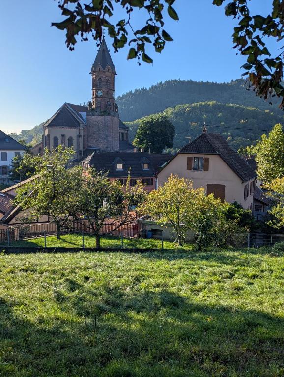 a large building with a clock tower in a field at Maison Mycélia in Buhl