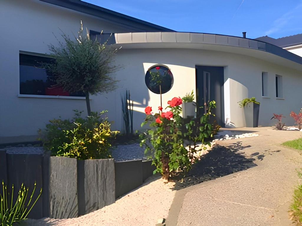 a house with flowers in front of it at L'Instant des Hôtes in Combrit