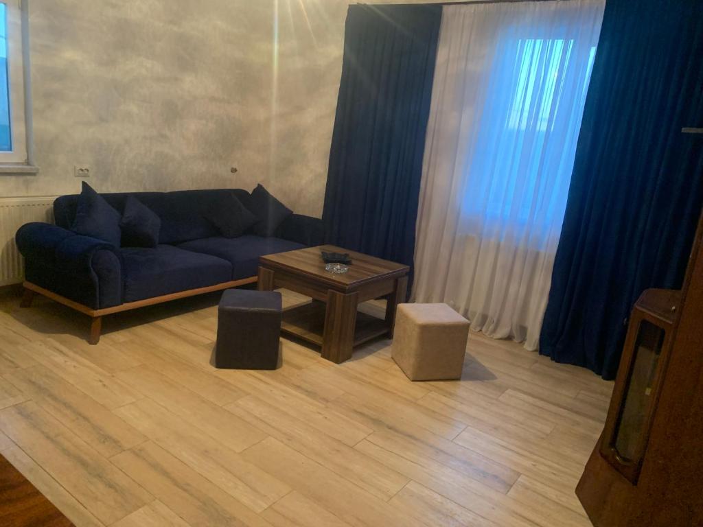 a living room with a blue couch and a table at Skyview House Tbilisi in Tbilisi City