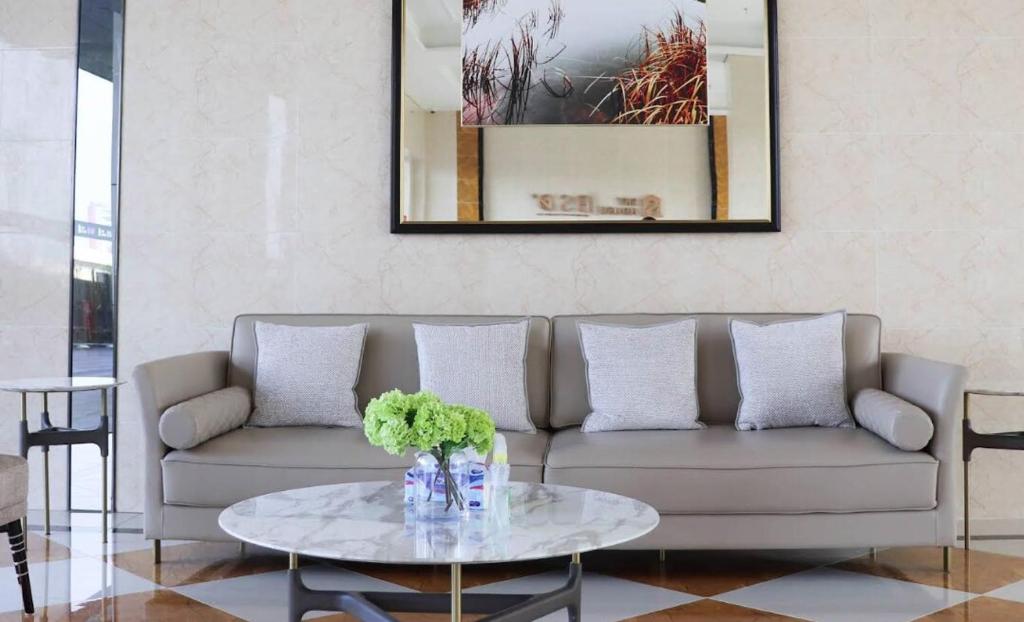 a living room with a couch and a table at Sky House BSD Apartment by Casanova in Cilenggang
