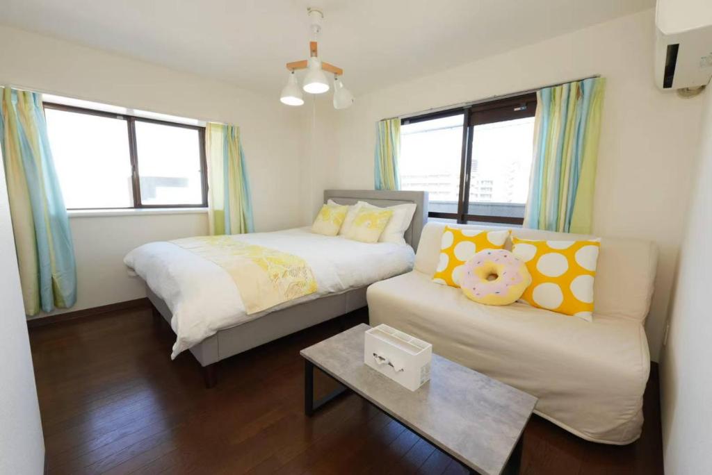a bedroom with a bed and a couch and windows at sakura 601 in Tokyo