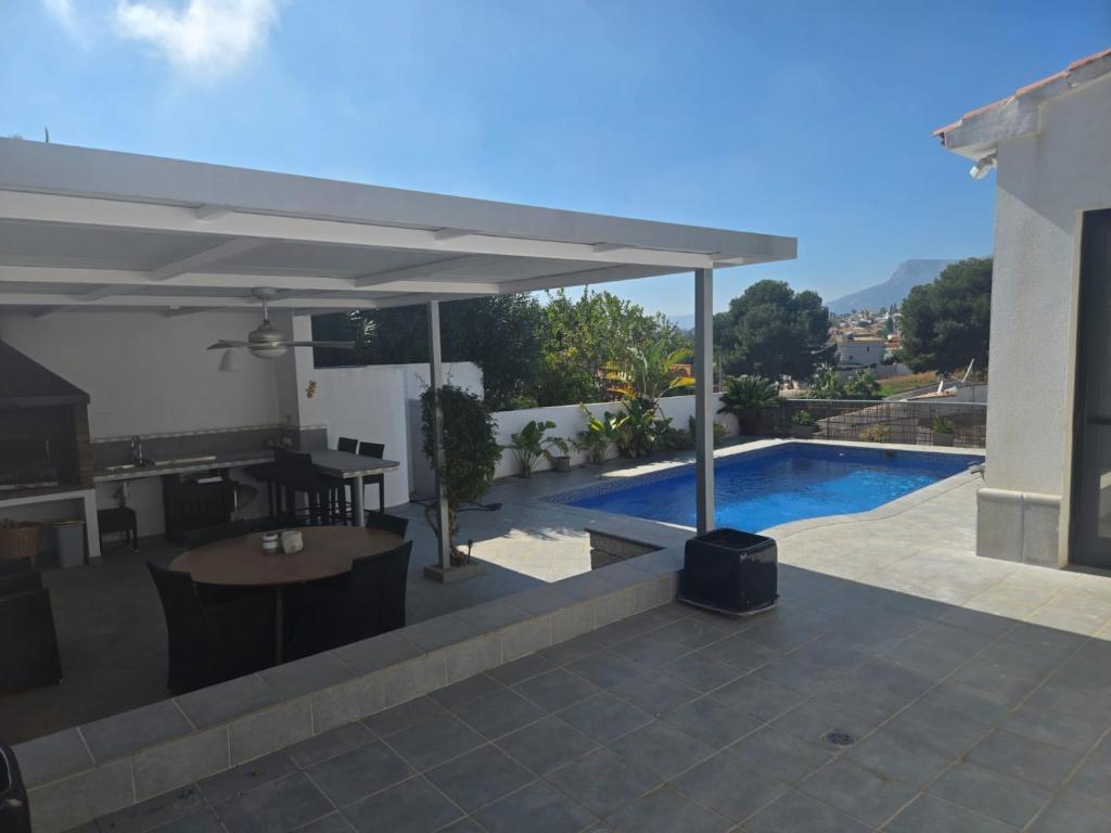 a patio with a swimming pool and a pavilion at Villa Good Vibes in Ifach