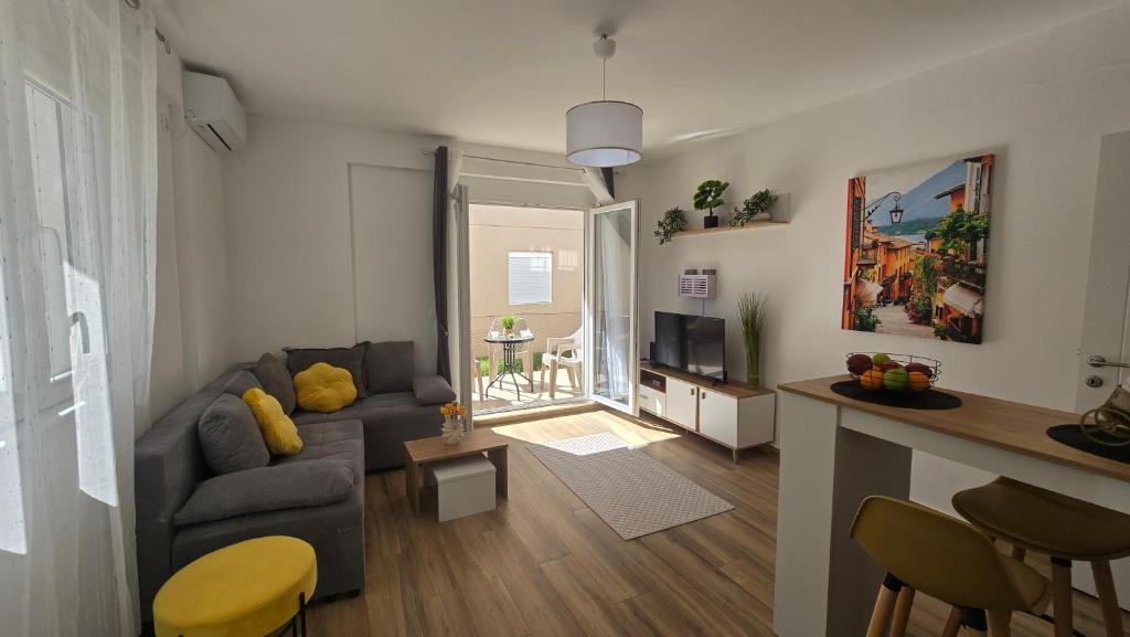 a living room with a couch and a television at Moderan apartman Klaudija in Igalo