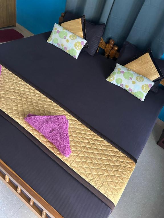 a bed with two pillows on top of it at Sea lumina in Varkala