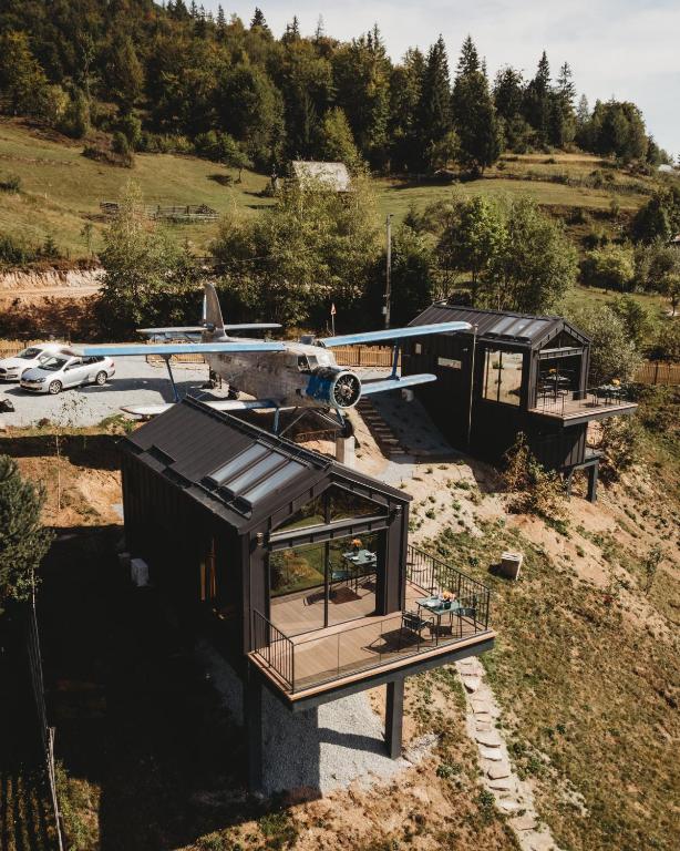 a house with a plane sitting on top of it at Cabana cu vedere spectaculoasa din pat - Apuseni Air Soare in Mătişeşti