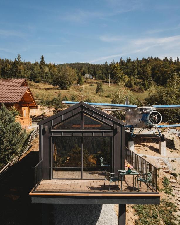 a house with a helicopter flying over it at Cabana romantica cu cer vizibil din pat - Apuseni Air Luna in Mătişeşti